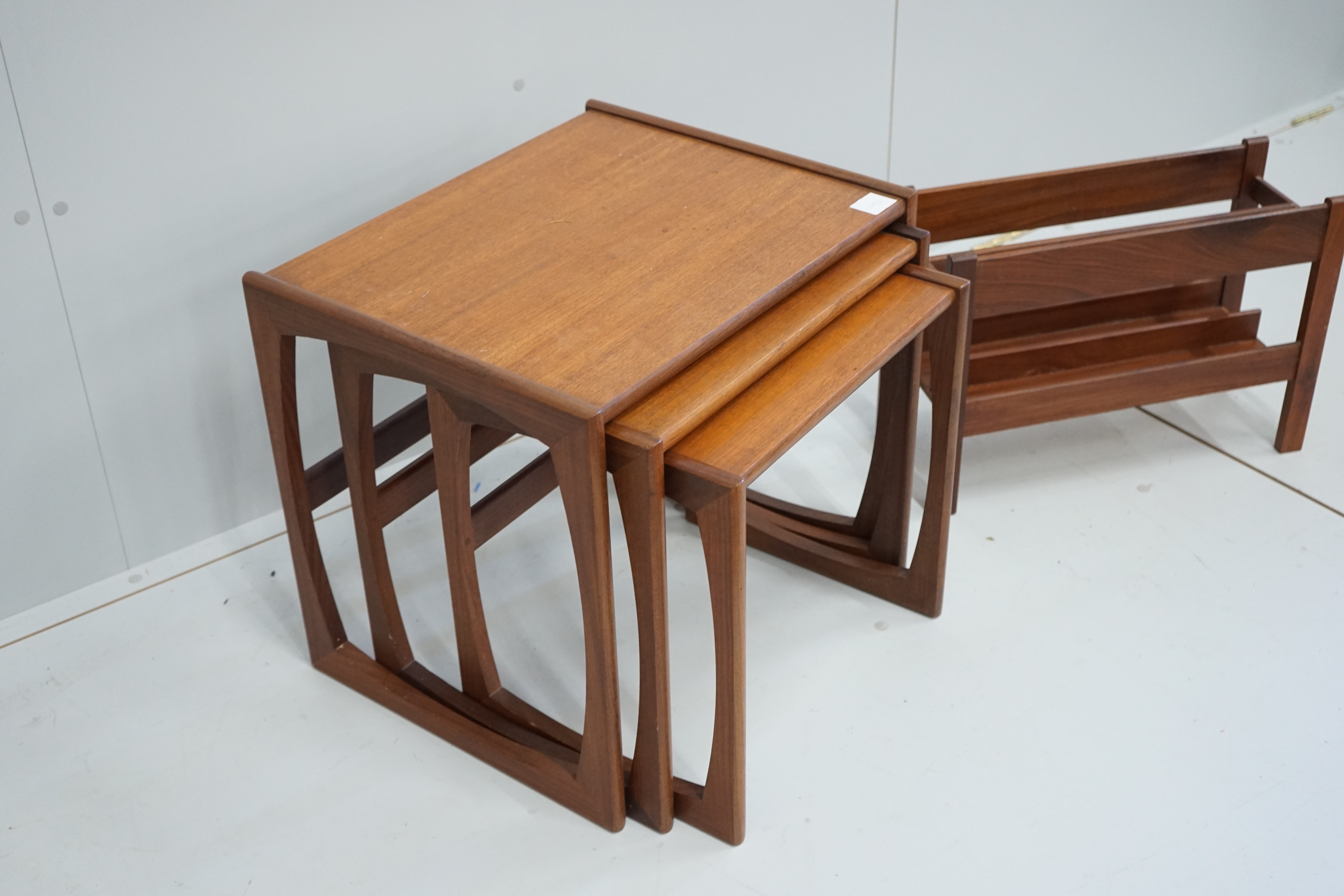 A nest of three G Plan teak tables, width 53cm, depth 43cm, height 49cm together with a two division Canterbury